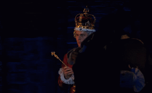 a man that is holding a violin wearing a crown