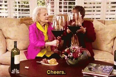 the older woman holds wine glasses and pours it into the glass