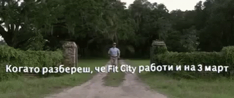 the man is walking towards the gate of the cemetery