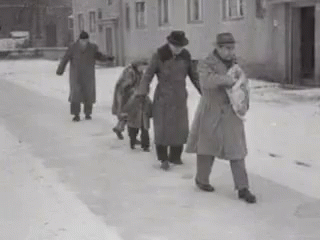 an old po of people walking down the snow covered sidewalk