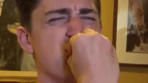 a man sneezing his nose with his hand