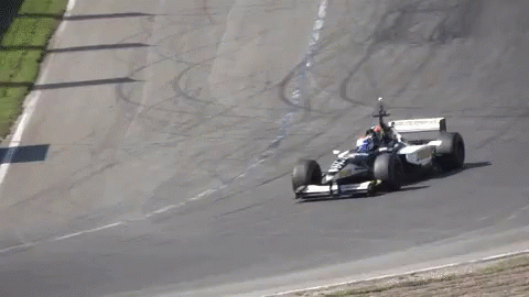 a racing car with a man on top going around the curve