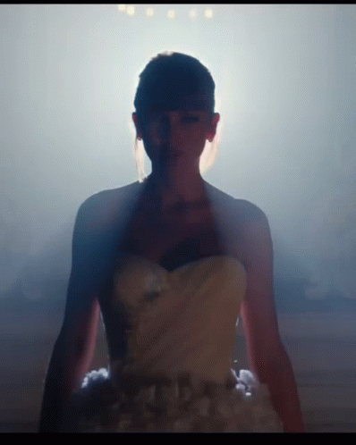 woman in dress standing in front of light and smoke