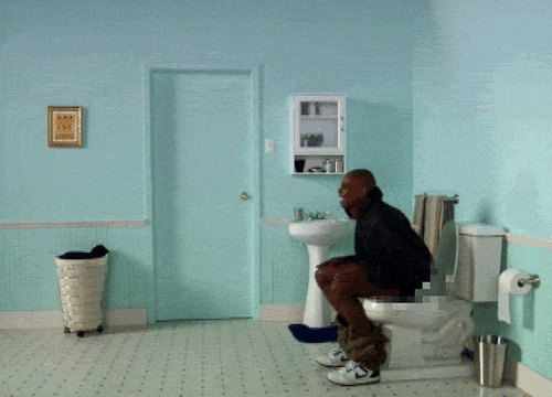 a man sitting on the toilet in a yellow bathroom
