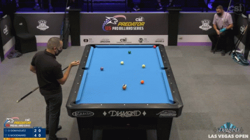 a man in black shirt playing a game of pool