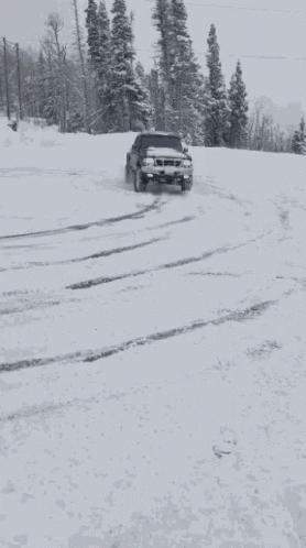 a truck drives down a snow covered road