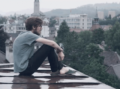a young man sits on top of the roof