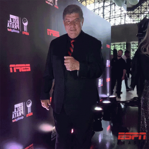 a person in a black suit and tie at a event