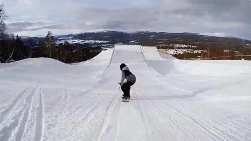 a person on a snowboard rides down the snowy slopes