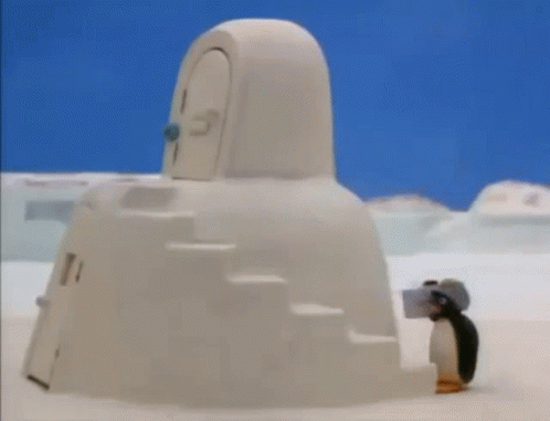 a small penguin standing in front of a big building