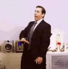 a man in a black suit is in front of a air conditioner
