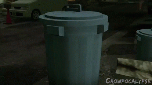 several green trash cans in a dark parking lot