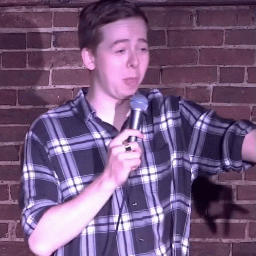 young man making a funny face while holding a microphone