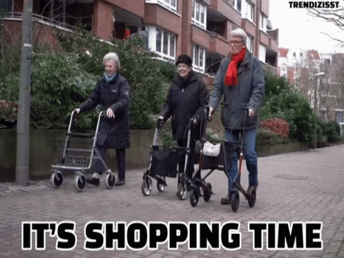 three older people are standing together and hing a cart