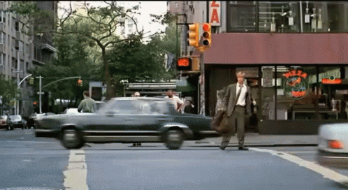 a person is walking across a crosswalk near a car