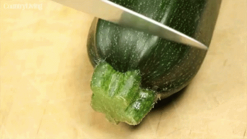 the knife has pulled the green plastic piece off of the bottom of a cucumber