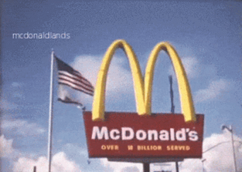 a billboard showing the logo for mcdonald's on a cloudy day