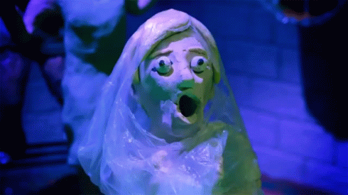 a creepy looking green ghost statue with a white veil