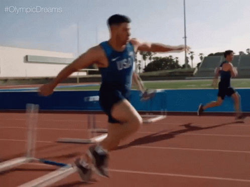 a male running on a track with another person