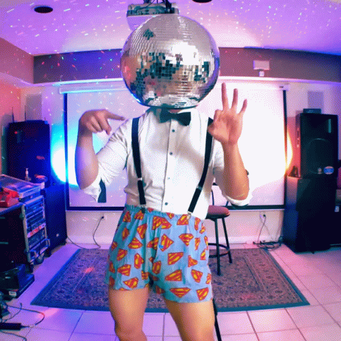 there is an alien dressed in shorts with a disco ball on his head