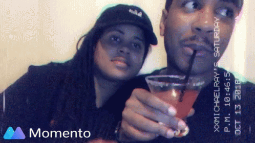two people are taking selfies with a drink