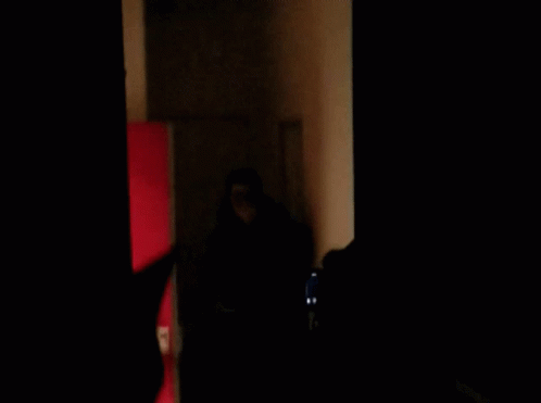 a dark room with several people standing in it