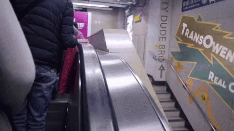 a person riding an escalator down a moving track