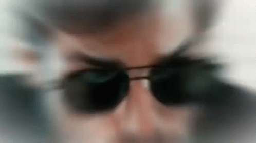 the reflection of a man with sunglasses in the mirror