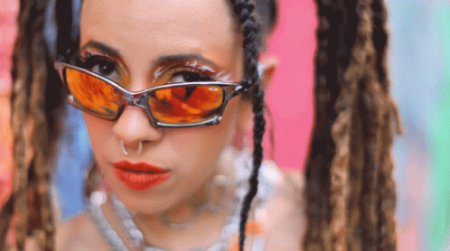 a woman with glasses and some dreadlocks on