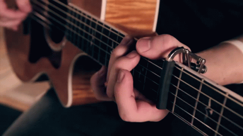 the finger on the left strings of a guitar