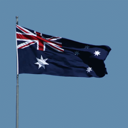 an australian flag in the wind with no clouds