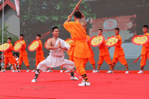 a man performs an oriental dance in front of some other men
