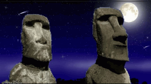 two statues made of stone against a red night sky