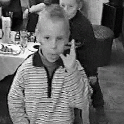 a boy showing the peace sign at a party