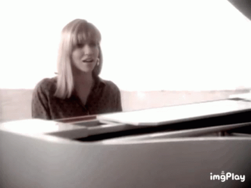 an image of a girl smiling near a piano