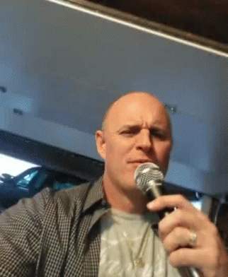 a man holding a microphone is making a speech