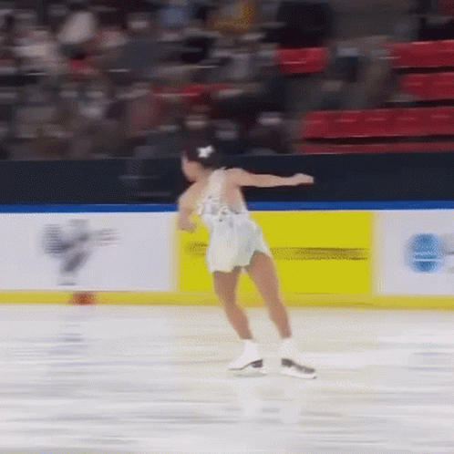 a man skating on an ice rink with one leg in the air