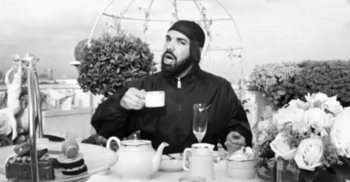 a man standing at a table with tea pots and coffee cups