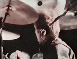a man with glasses is playing drums