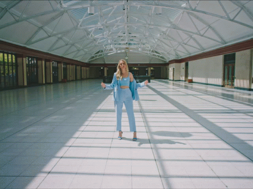 a girl wearing yellow walking in a large airport