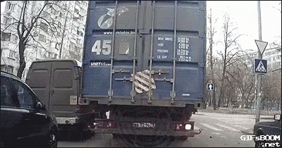 a large truck driving down a street near tall buildings