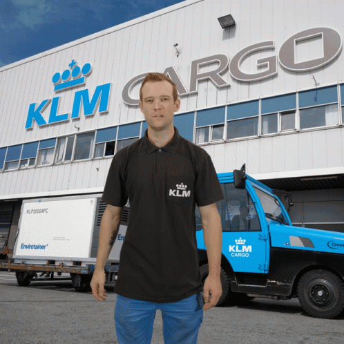 a guy in black shirt standing outside a truck