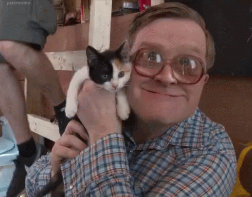 the man with glasses holds his cat in his arms