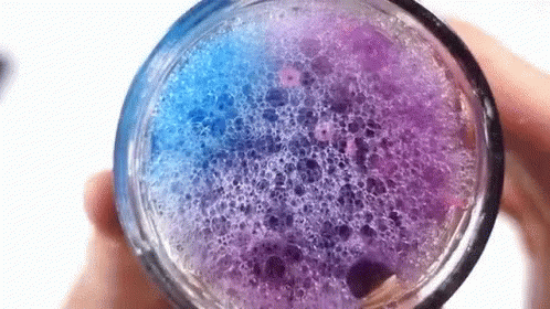 a glass with purple liquid and some yellow substance inside