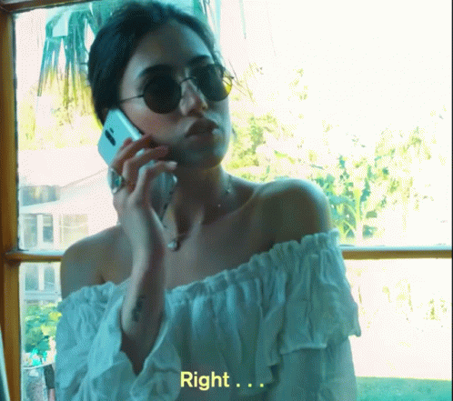 a woman wearing sunglasses is talking on a cellphone
