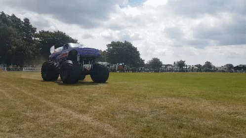a large tractor that is riding on the blue grass