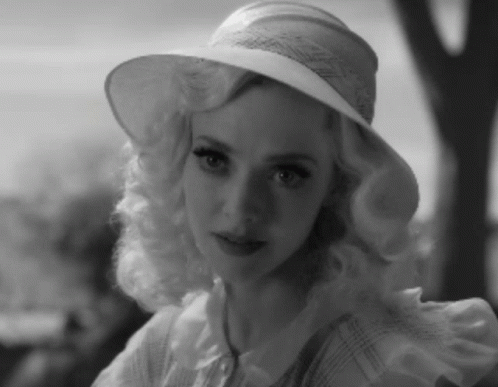 a woman wearing a white hat posing for the camera