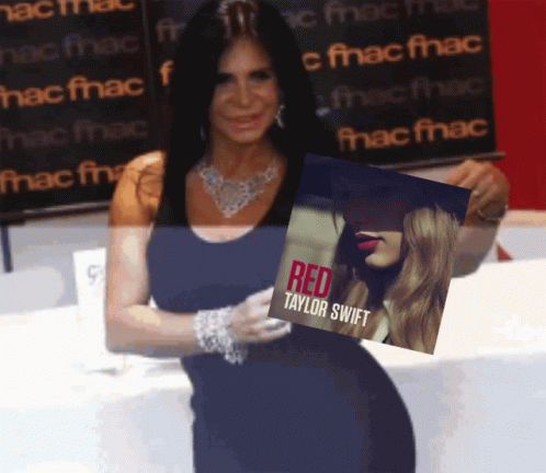 a woman holding up a red taylor sweet album