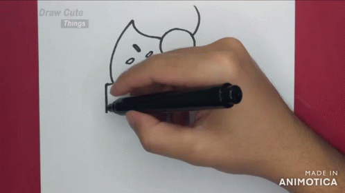 the hand is drawing on the paper, and he's holding the black pen