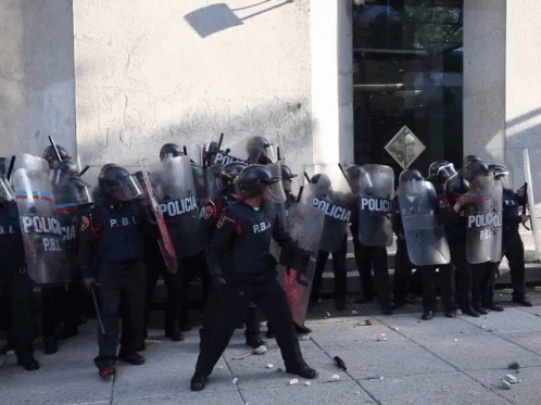 a row of people with riot gear standing next to each other